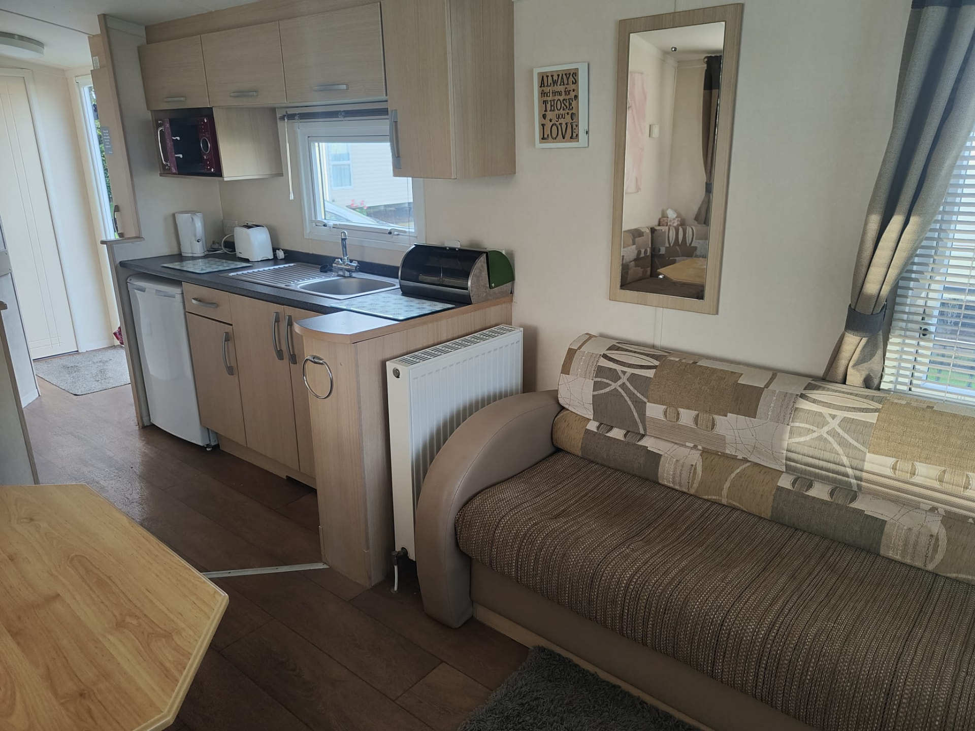Kitchen and lounge seating inside holiday caravan A13