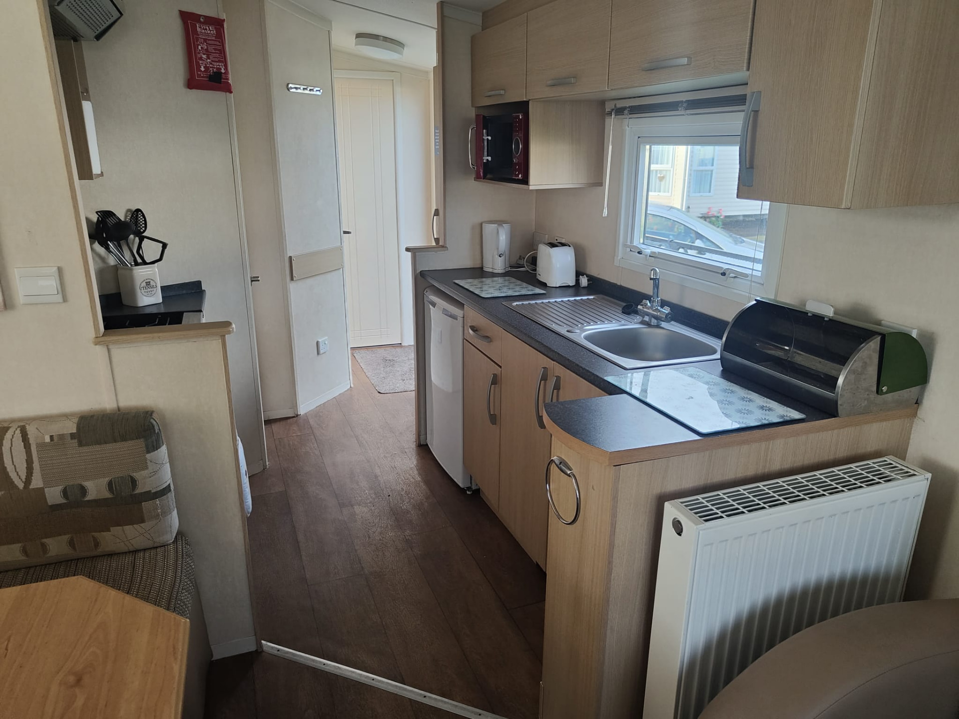 Kitchen area with sink and microwave inside caravan A13